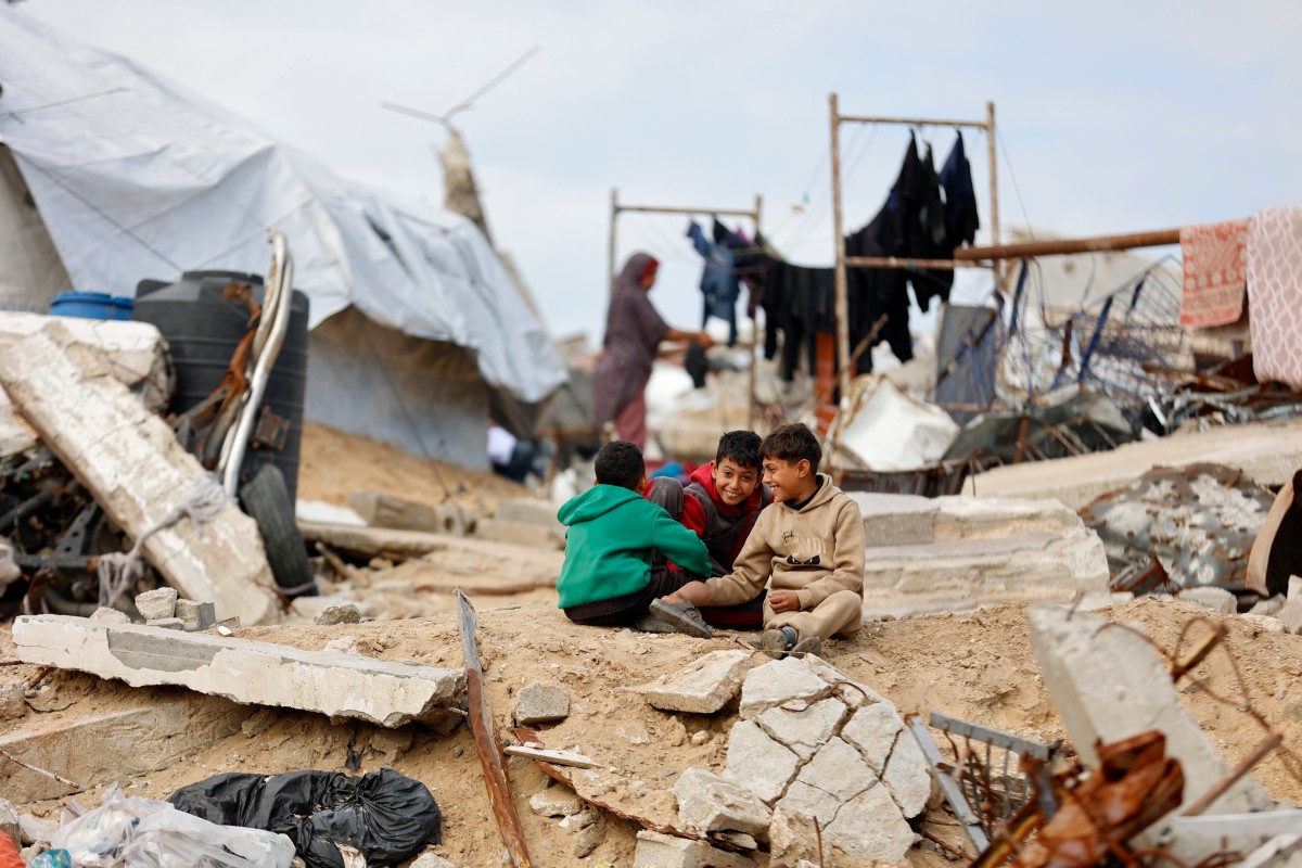 أطفال فلسطينيون نازحون يلعبون بين أنقاض وحطام المنازل والمتاجر التي دمرها الجيش الإسرائيلي في غزة. (أ ف ب)