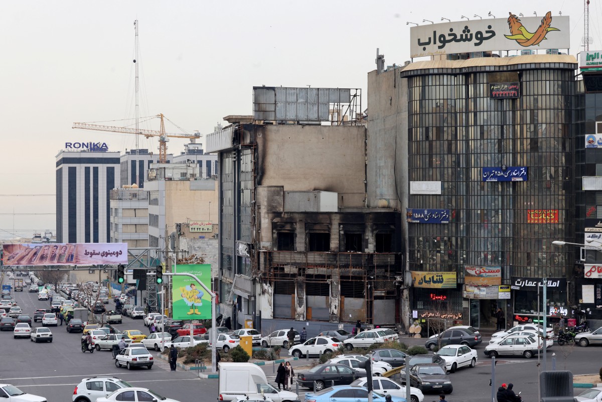  مبنى محترق دُمر خلال احتجاجات شعبية في العاصمة الإيرانية طهران. (أ ف ب)