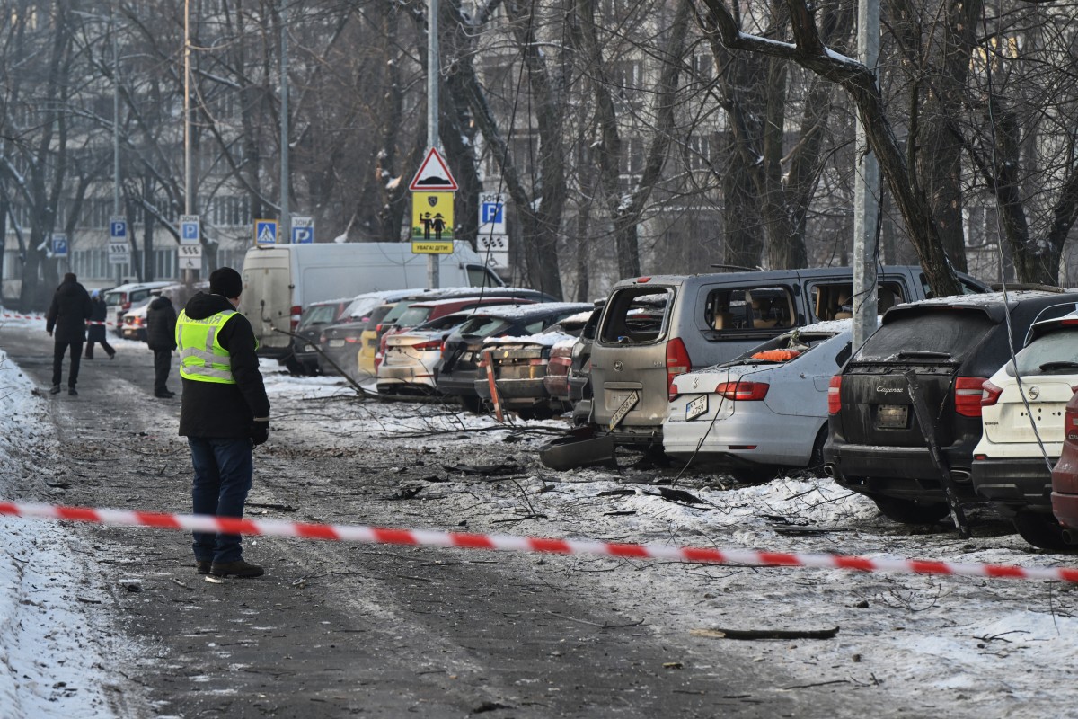 يتفقد السكان السيارات المتضررة في الموقع الذي سقطت فيه حطام الطائرات الروسية المسيرة خلال هجوم جوي روسي واسع النطاق على كييف. (أ ف ب)