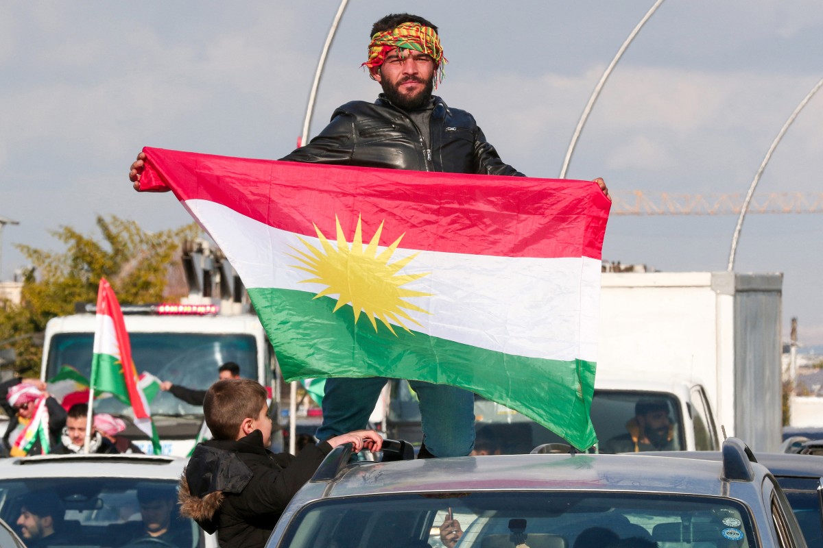 متظاهر يحمل علم كردستان خلال تظاهرة لدعم الأكراد في سوريا. (أ ف ب)