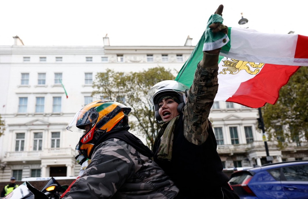 متظاهرون مناهضون للنظام الإيراني يلوحون بأعلام إيرانية خلال مظاهرة بالسيارات أمام السفارة الإيرانية في وسط لندن (أ ف ب)