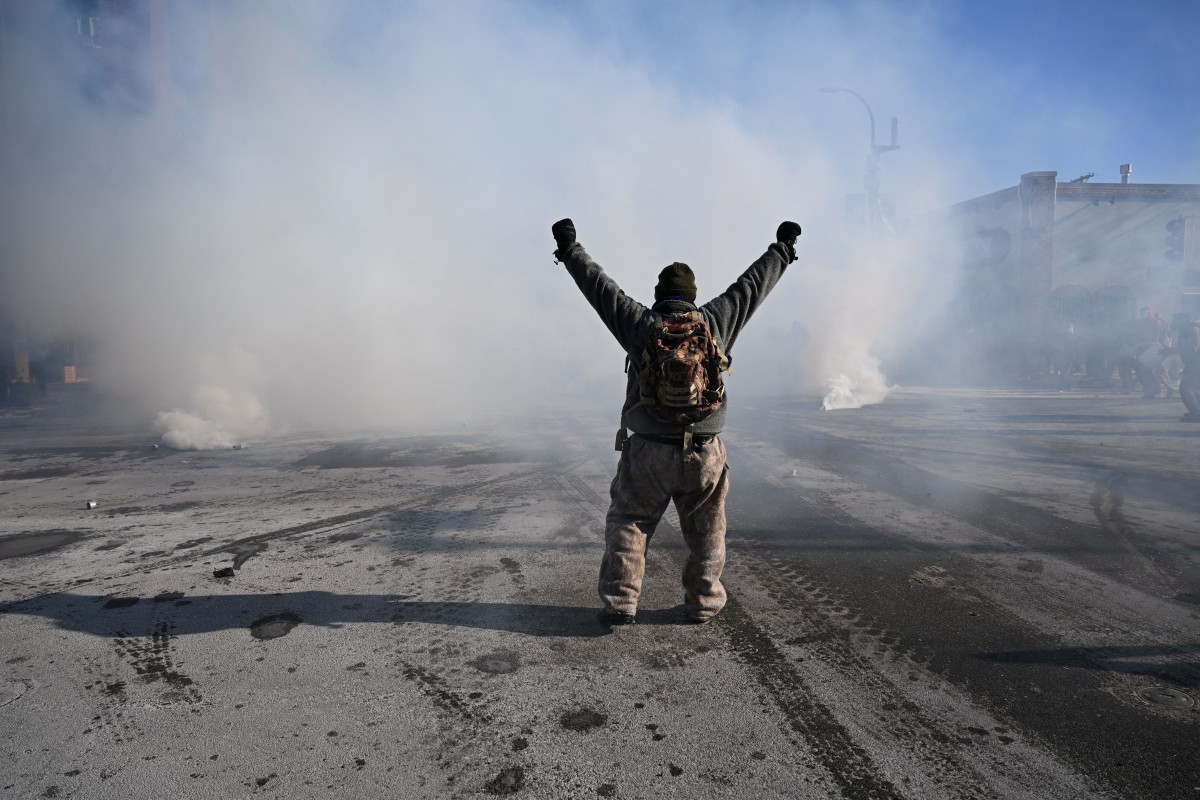 متظاهر يواجه وابلاً من قذائف الغاز التي أطلقتها الشرطة في منيابوليس بولاية مينيسوتا. (أ ف ب)
