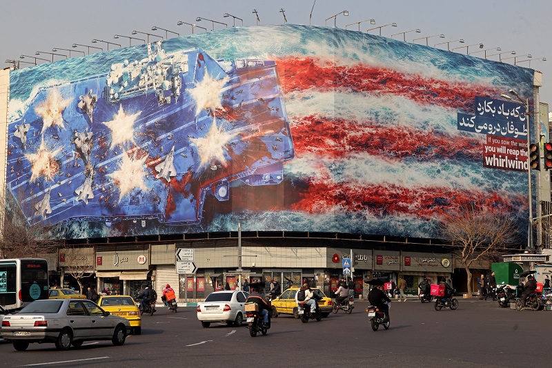 سيارات تمر أمام لافتة معادية للولايات المتحدة مثبتة على مبنى في ميدان إنقلاب في طهران، (ا ف ب).