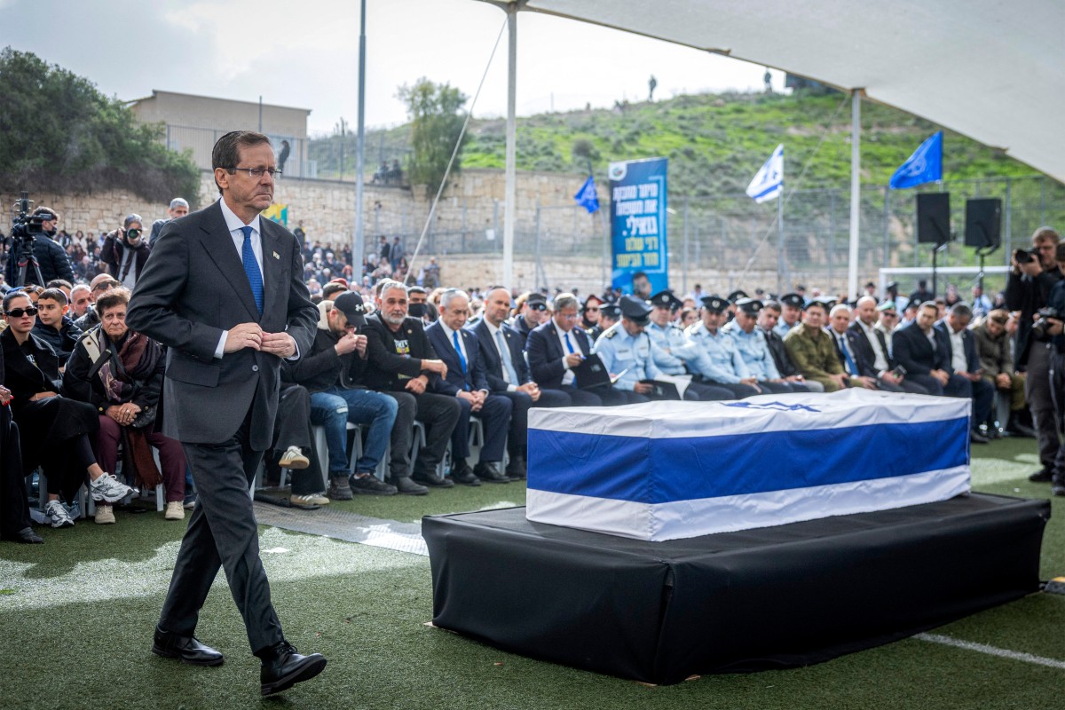 الرئيس الإسرائيلي إسحاق هيرزوغ يمر أمام نعش الرهينة الإسرائيلية ران جفيلي. (أ ف ب)