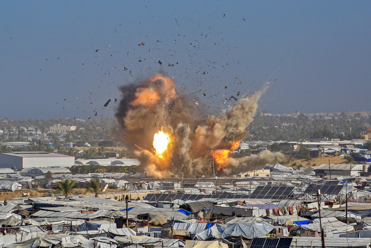 دخان ونيران تتصاعد من مأوى غات، الذي يؤوي فلسطينيين نازحين، بعد غارة جوية إسرائيلية في غرب خان يونس، جنوب قطاع غزة. (أ ف ب)