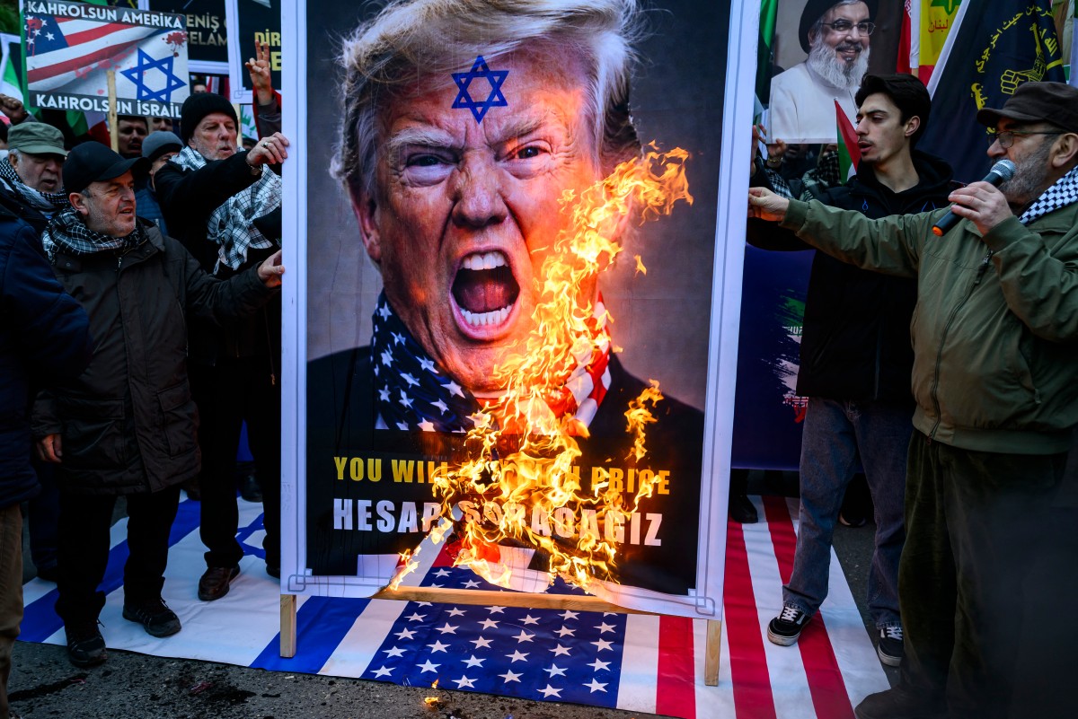 متظاهرون يُضرمون النار في صورة للرئيس الأميركي دونالد ترامب خلال تظاهرة مناهضة للولايات المتحدة أمام القنصلية الأميركية في إسطنبول. (أ ف ب)