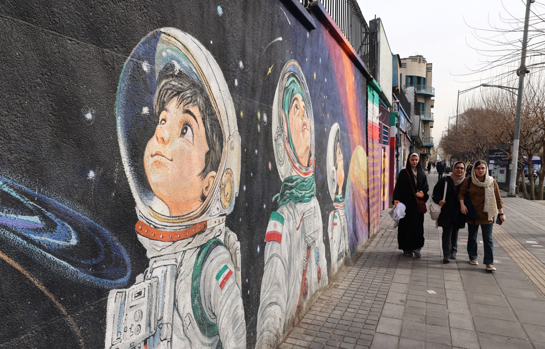 جدارية تصوّر أطفالاً كعلماء المستقبل، في طهران. (أ ف ب)