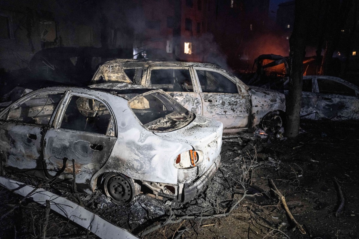 سيارات محترقة في فناء مبنى سكني متضرر في أعقاب هجوم جوي في كراماتورسك، منطقة دونيتسك، وسط الغزو الروسي لأوكرانيا. (أ ف ب)