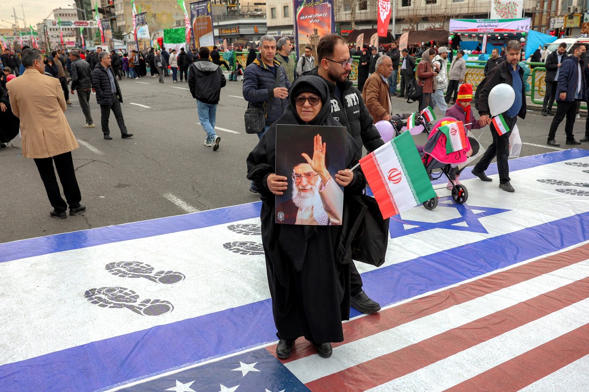 سيدة إيرانية تحمل صورة المرشد الأعلى آية الله علي خامنئي خلال تجمع لإحياء الذكرى السابعة والأربعين للثورة الإسلامية، في طهران، 11 شباط 2026. (أ ف ب)