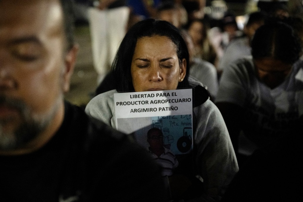 امرأة تعانق صورة أحد أقاربها خلال وقفة احتجاجية لأقارب السجناء السياسيين خارج سجن إل روديو الأول في غواتير، ولاية ميراندا، فنزويلا (أ ف ب)