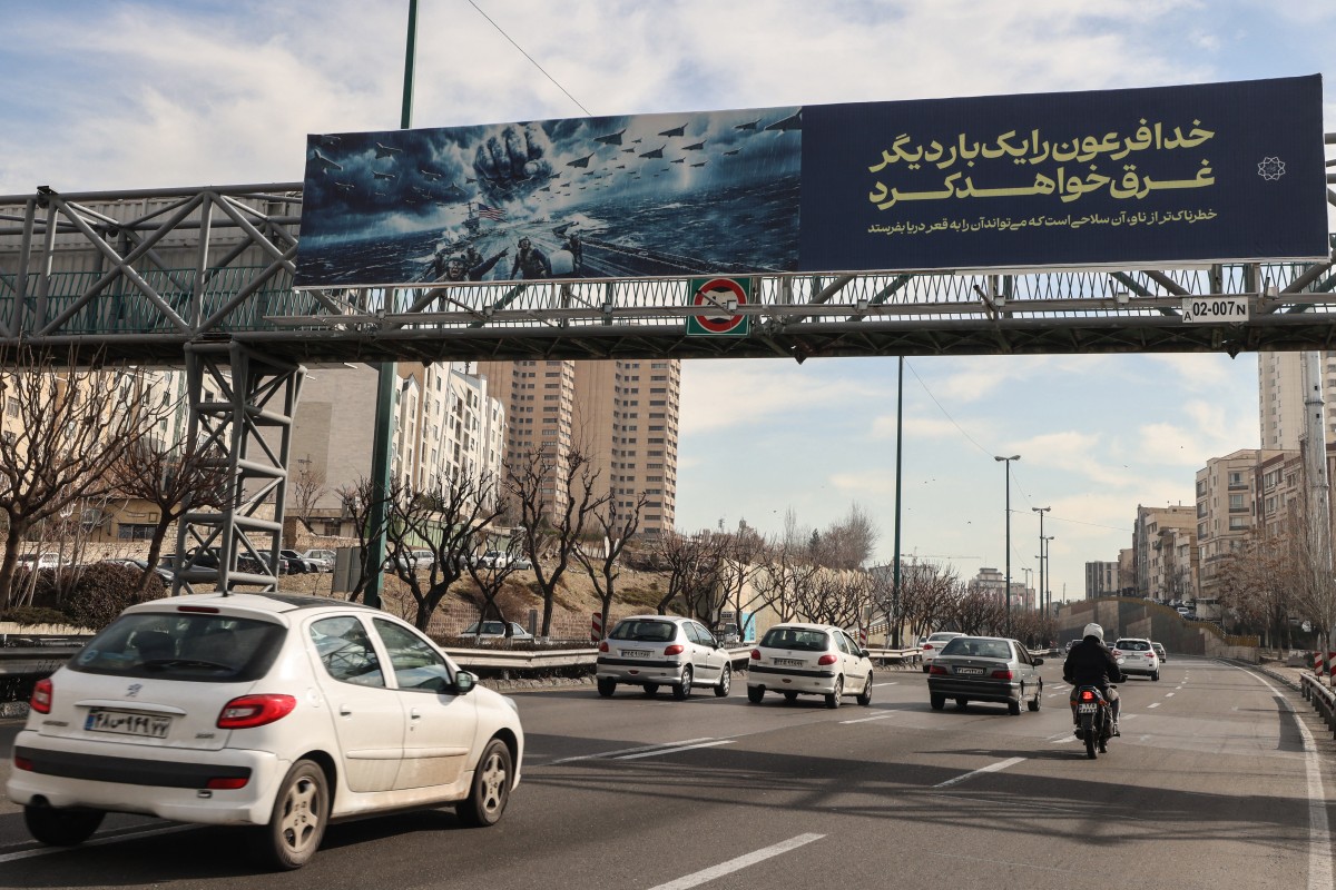 لافتة تهديد بإغراق حاملة الطائرات الأميركية، معلقة على جسر للمشاة في طهران. (أ ف ب)