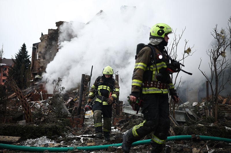 رجال إنقاذ أوكرانيون يعملون في موقع منزل متضرر بشدة جراء غارة جوية في كييف، (أ ف ب).