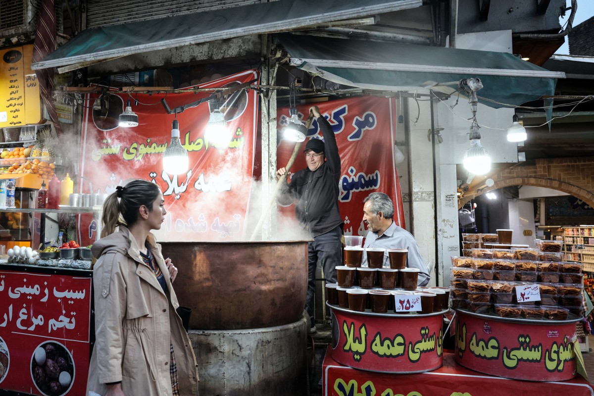 سيدة إيرانية تمر أمام متجر يبيع الحلويات في شمال طهران. (أ ف ب)