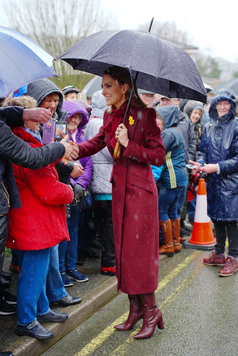 كيت ميدلتون بالمعطف البرغندي المكرر في ويلز (أ.ف.ب)