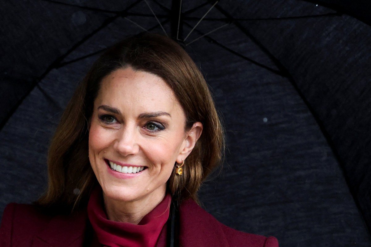 كيت ميدلتون بالمعطف البرغندي المكرر في ويلز (أ.ف.ب)