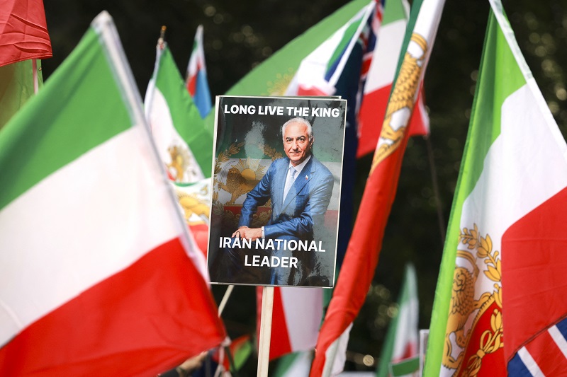 أعضاء من الجالية الإيرانية يرفعون صورة لرضا بهلوي في سيدني، (ا ف ب).