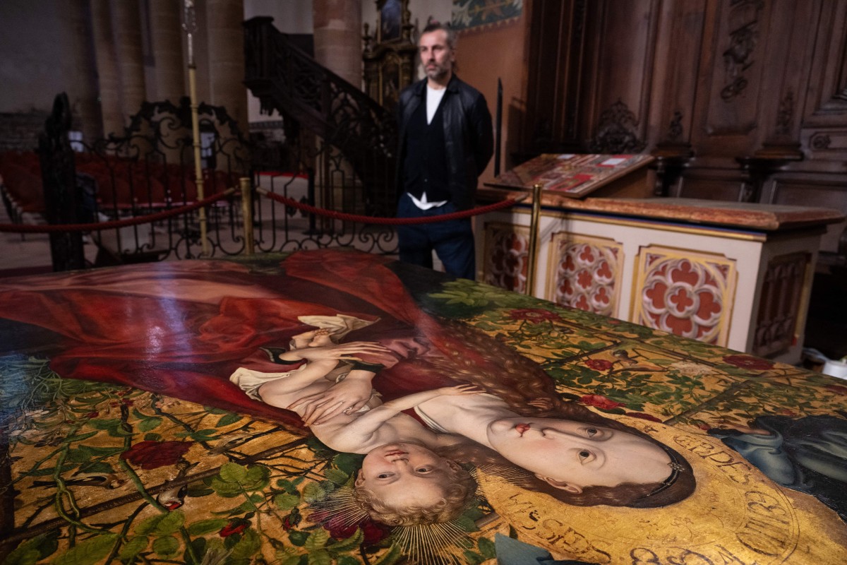 تخضع اللوحة للترميم تحت أنظار الجمهور. (أ ف ب)