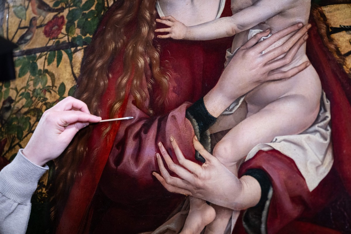 إزالة الغبار والشوائب عن سطح اللوحة. (أ ف ب)