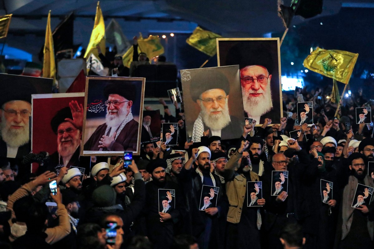 رجال دين شيعة عراقيون يحملون صور خامنئي أثناء مسيرة باتجاه السفارة الأميركية في بغداد. (أ ف ب)