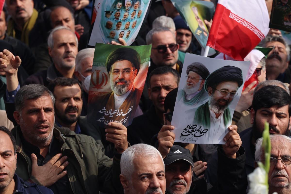 رفع الإيرانيون ملصقات تحمل صور المرشد الأعلى الإيراني الراحل علي خامنئي وابنه، المرشد الأعلى الجديد للبلاد مجتبى خامنئي. (أ ف ب)