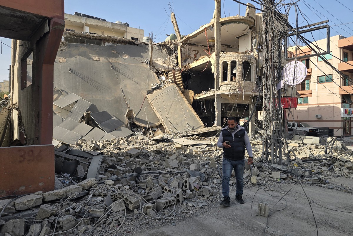 رجل يقف أمام أنقاض مبنى مدمر جراء غارات إسرائيلية على مدينة صور، جنوب لبنان. (أ ف ب)
