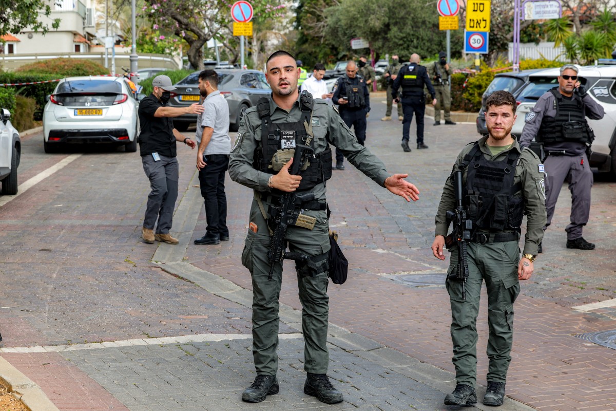 قوات الأمن الإسرائيلية تتجمع في موقع سقوط صاروخ إيراني بوسط إسرائيل (أ ف ب).