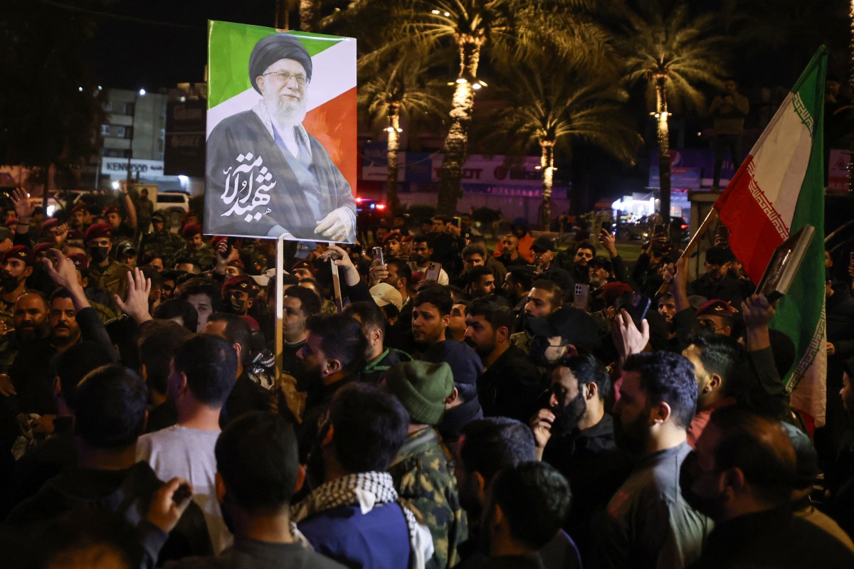 متظاهرون في العراق يحملون صورة خامنئي. (أ ف ب)