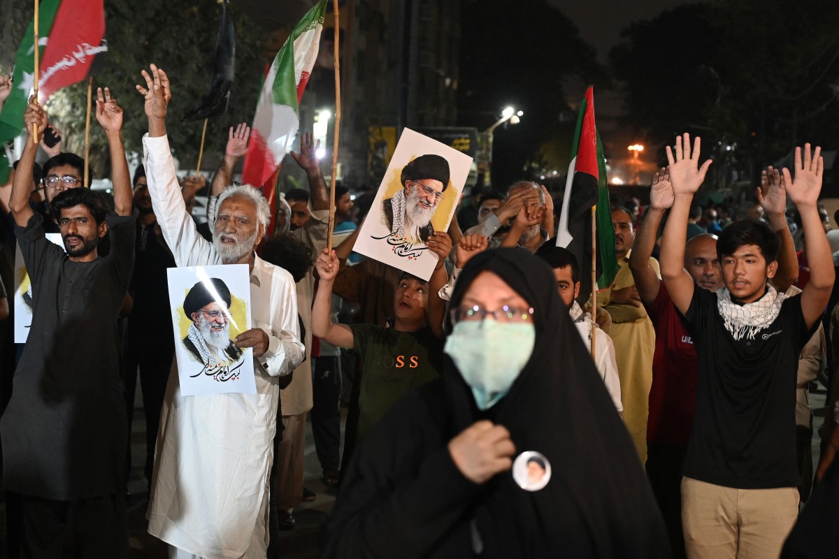  باكستانيون يحملون صوراً للمرشد الأعلى الإيراني الراحل علي خامنئي (أ ف ب). 