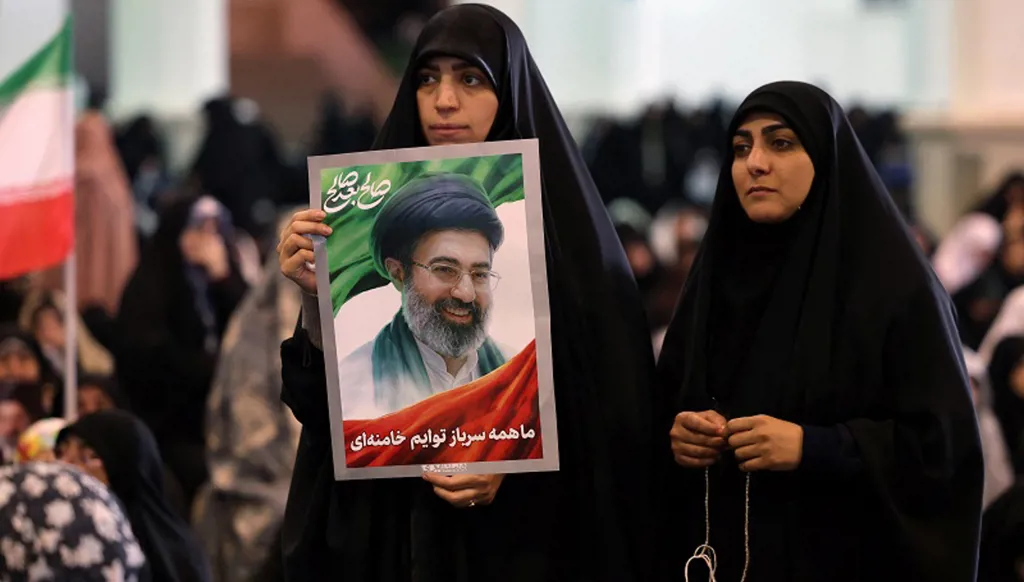 إيرانية تحمل صورة المرشد الأعلى الإيراني آية الله مجتبى خامنئي خلال صلاة عيد الفطر طهران. (ا ف ب).