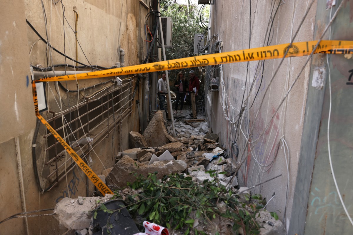 تنتشر الحجارة والأنقاض في الزقاق عقب انفجار يُقال إنه نجم عن صاروخ أو شظايا صاروخ اعتراضي في تل أبيب (أ ف ب)