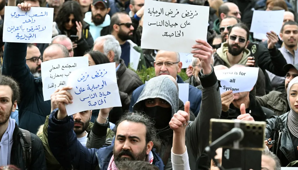 سوريون يشاركون باحتجاج في حي باب توما في دمشق، في 22 آذار 2026. (أ ف ب)