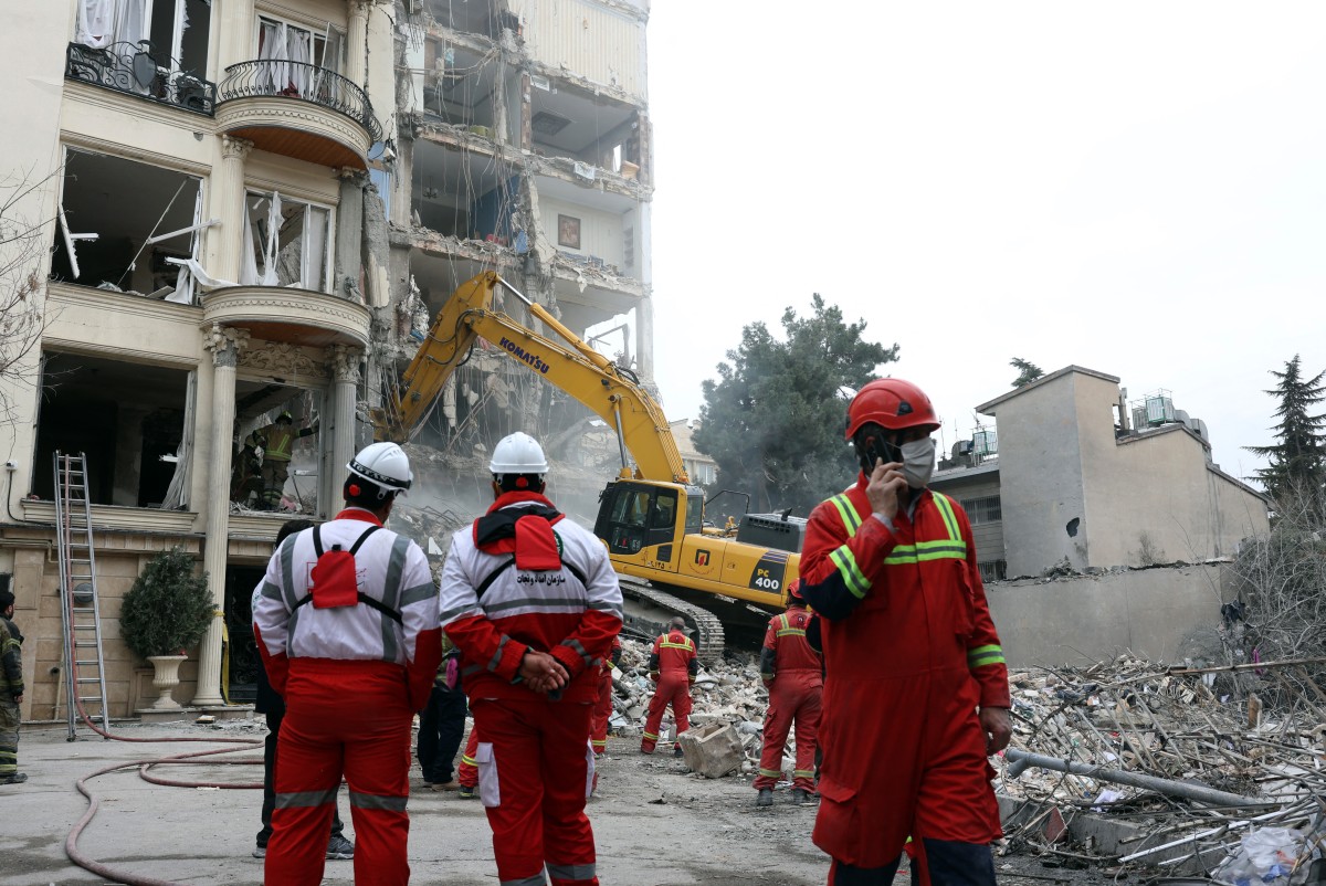 رجال إنقاذ في موقع غارة إسرائيلية في طهران. (أ ف ب)
