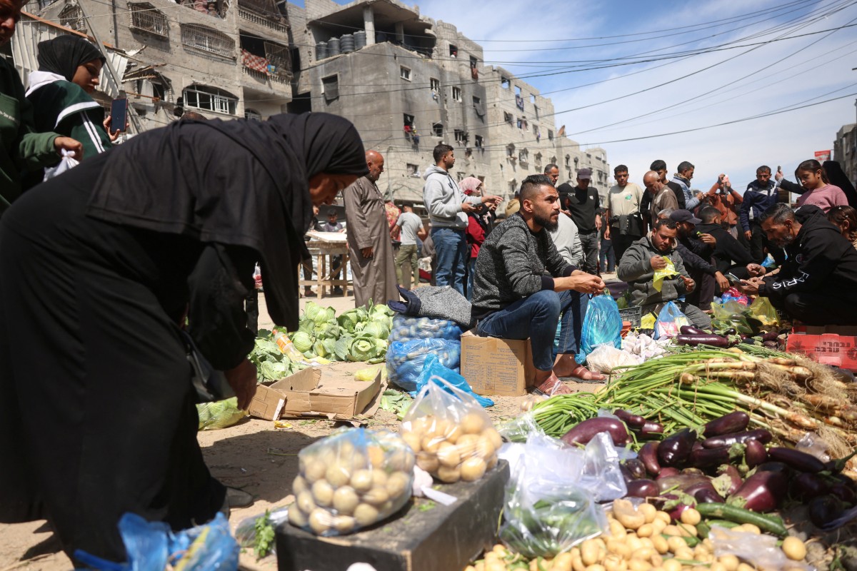 فلسطينيون نازحون يتسوقون لشراء الطعام في سوق مفتوح في خان يونس، جنوب قطاع غزة. (أ ف ب)
