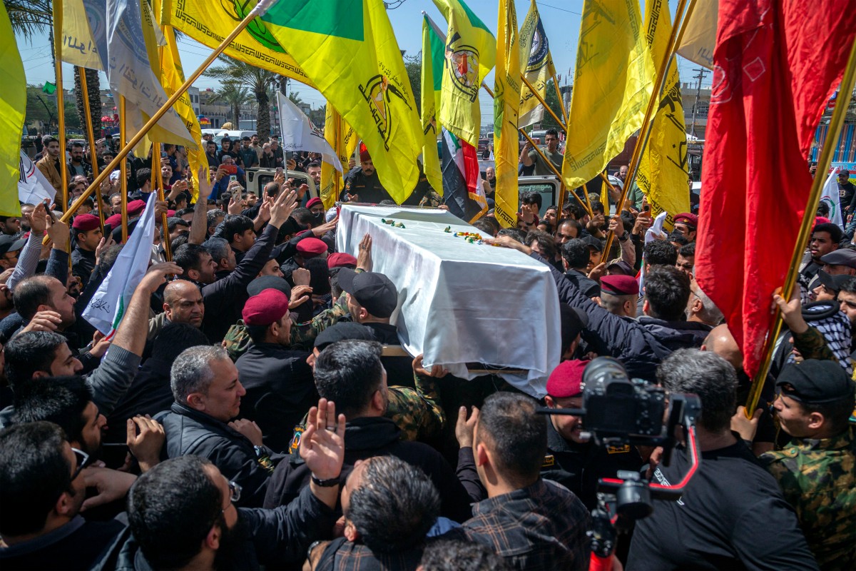عناصر من كتائب حزب الله، خلال مراسم تشييع زميل لهم في مدينة الصدر ببغداد. (أ ف ب)