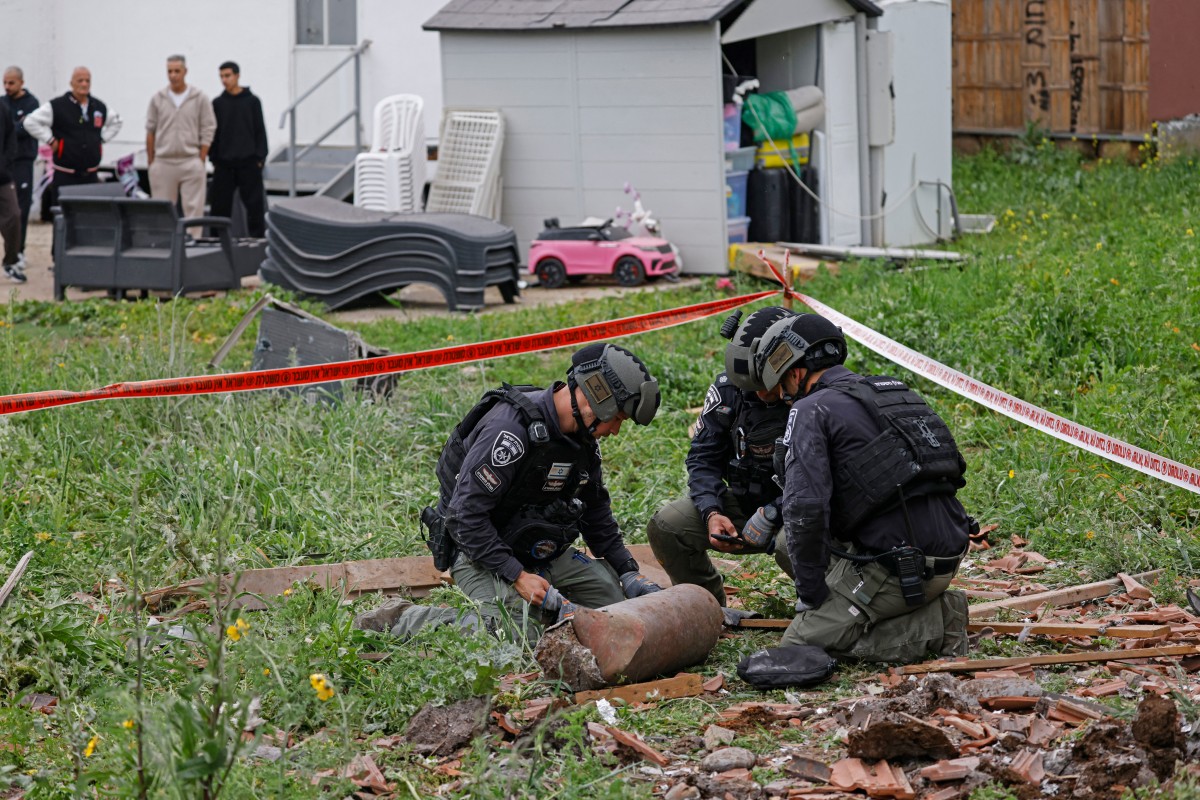 تتجمع قوات الأمن الإسرائيلية في موقع قصف صاروخي شنه حزب الله واستهدف منزلاً في بلدة كريات شمونة