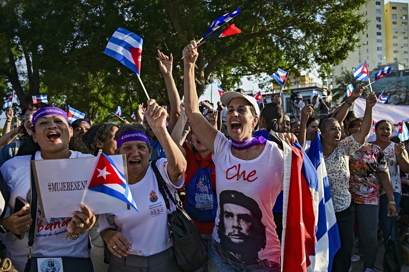 نساء يحملن أعلام كوبا، وترتدي إحداهن قميصاً عليه صورة الزعيم الثوري الأرجنتيني المولد إرنستو تشي غيفارا، يشاركن في مظاهرة ضد العقوبات الاميركية والحظر النفطي، في هافانا، (أ ف ب).