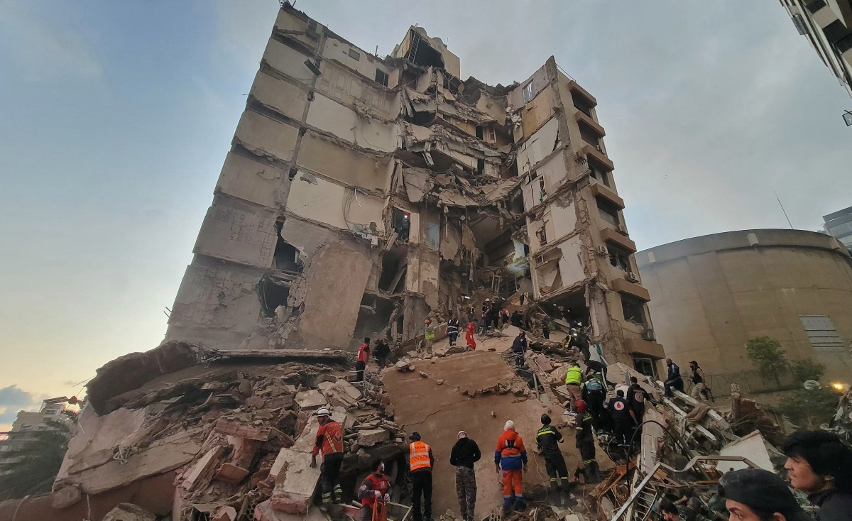 مسعفون وسكان يتجمعون في موقع غارة إسرائيلية في بيروت. (أ ف ب)