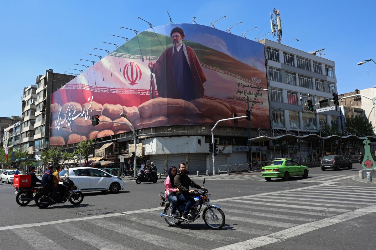 رفع صورة مجتبى خامنئي وسط طهران (أ ف ب). 