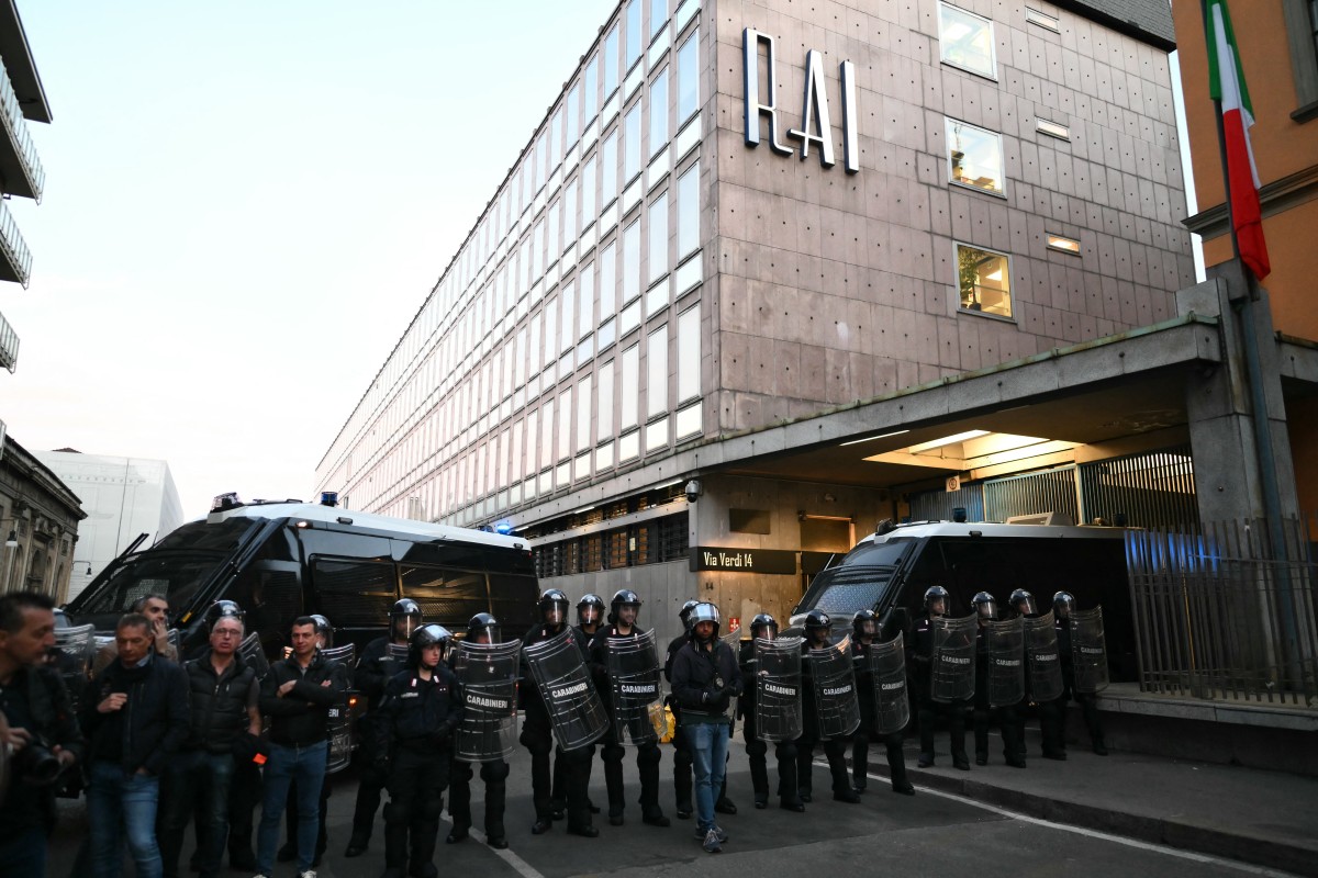 يقف أفراد من قوات الكارابينيري الإيطالية يرتدون ملابس مكافحة الشغب بالقرب من استوديوهات هيئة الإذاعة والتلفزيون الوطنية 