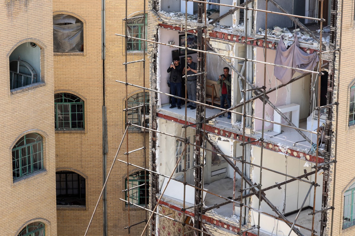 صحافيون داخل مبنى سكني فقد واجهته جراء غارات أميركية-إسرائيلية، جنوب طهران. (أ ف ب)