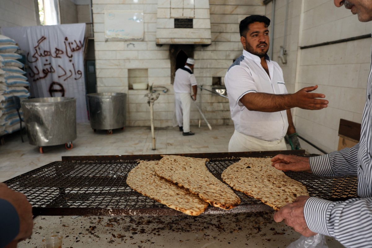 رجل إيراني يشتري الخبز من أحد الأفران في جنوب طهران. (أ ف ب)