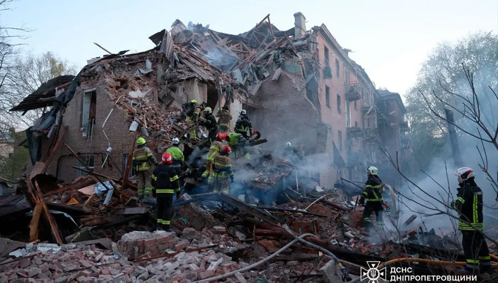 فرق الإنقاذ الأوكرانية وهي تزيل الأنقاض من مبنى سكني عقب هجوم روسي في مدينة دنيبرو (أ ف ب). 