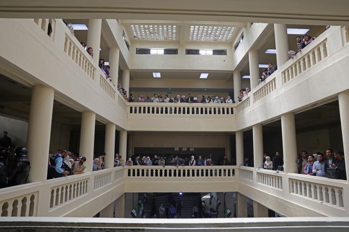 عناصر أمن وحضور يتجمعون في القصر العدلي في دمشق. (أ ف ب)