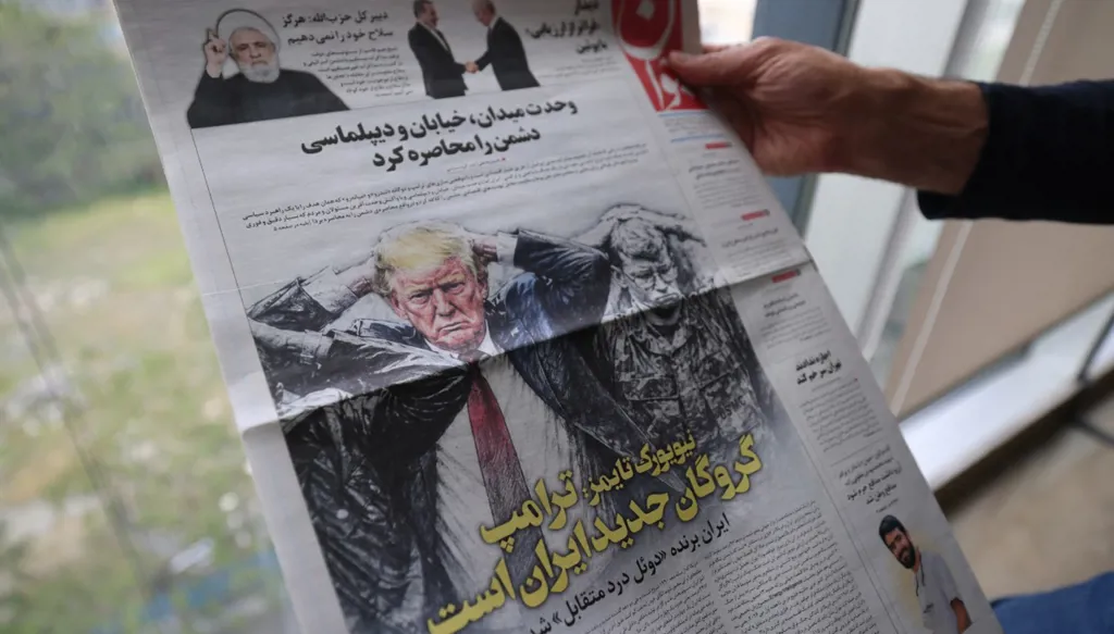 شخص يعرض الصفحة الأولى لصحيفة "جافان" الصادرة باللغة الفارسية، والتي تحمل عنوان "ترامب هو رهينة إيران الجديدة" (أ ف ب). 
