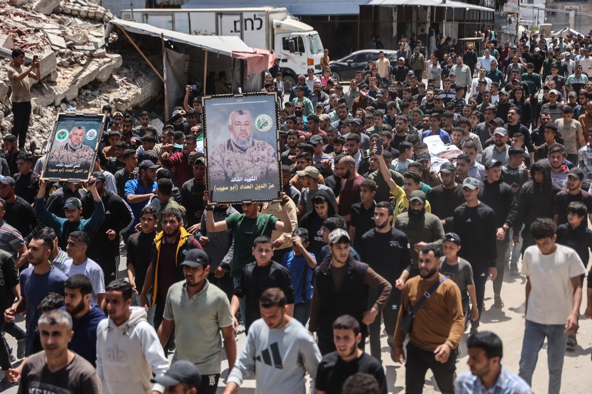 فلسطينيون يحملون صور القائد العام لكتائب القسام عز الدين الحداد خلال مراسم تشييعه في مدينة غزة. (أ ف ب)