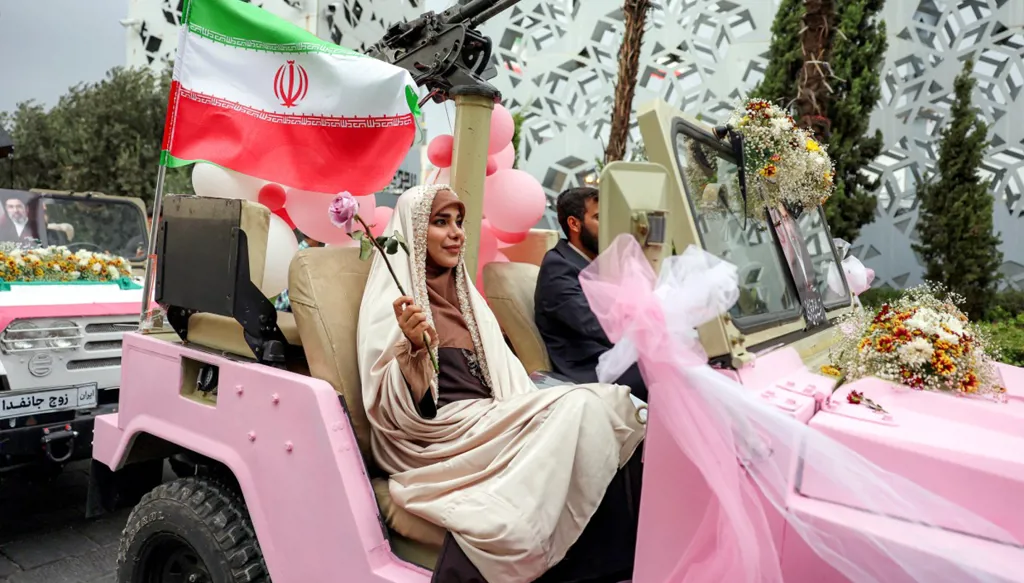 سيارات جيب عسكرية مزوّدة بمدافع رشاشة... زفافات جماعية بطابع حربي في طهران (صور)
