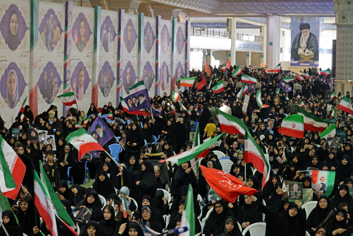 مناصرون للنظام الإيراني يرفعون العلم الإيراني في طهران (أ ف ب).