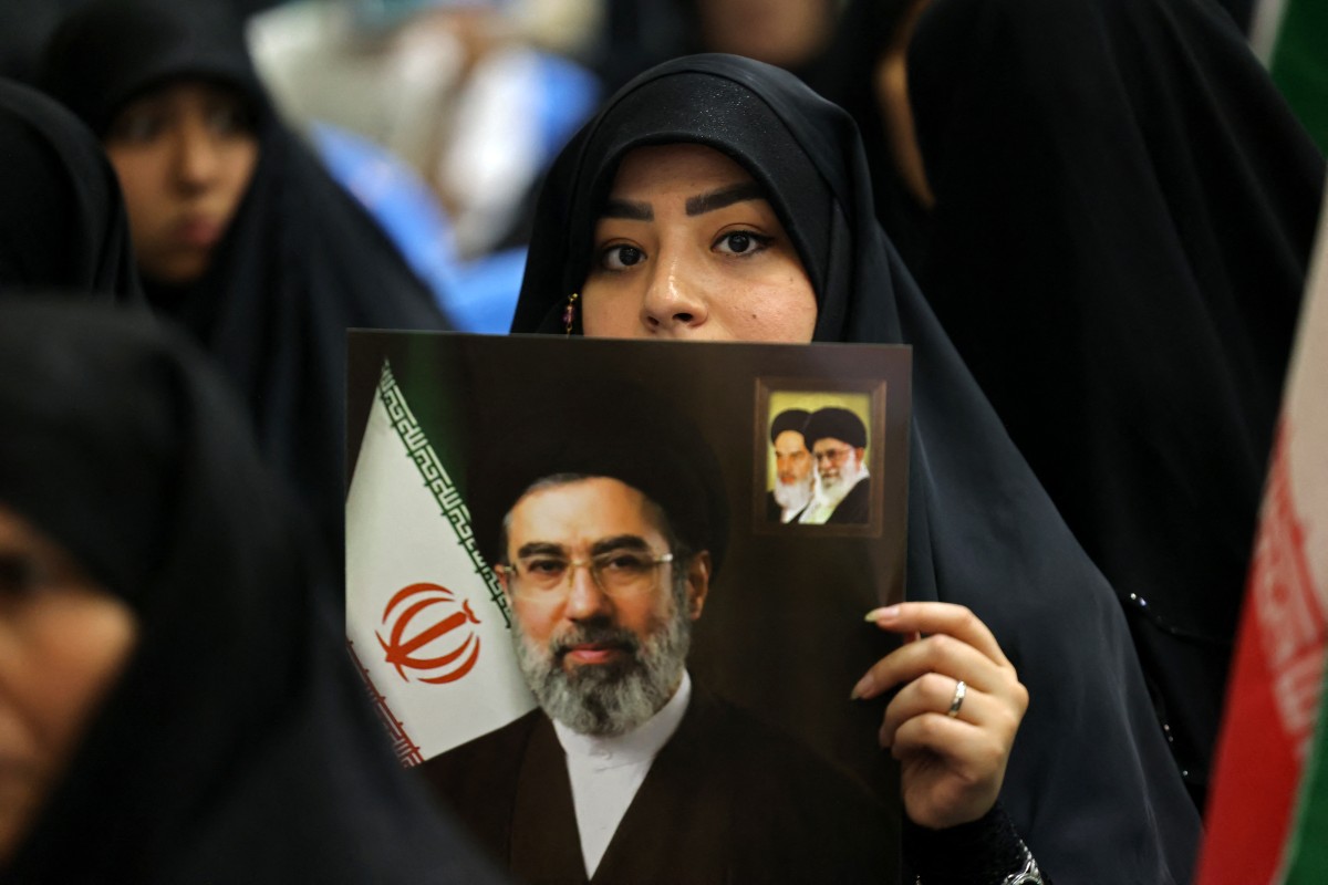 سيدة ترفع صورة خامنئي في طهران (أ ف ب).