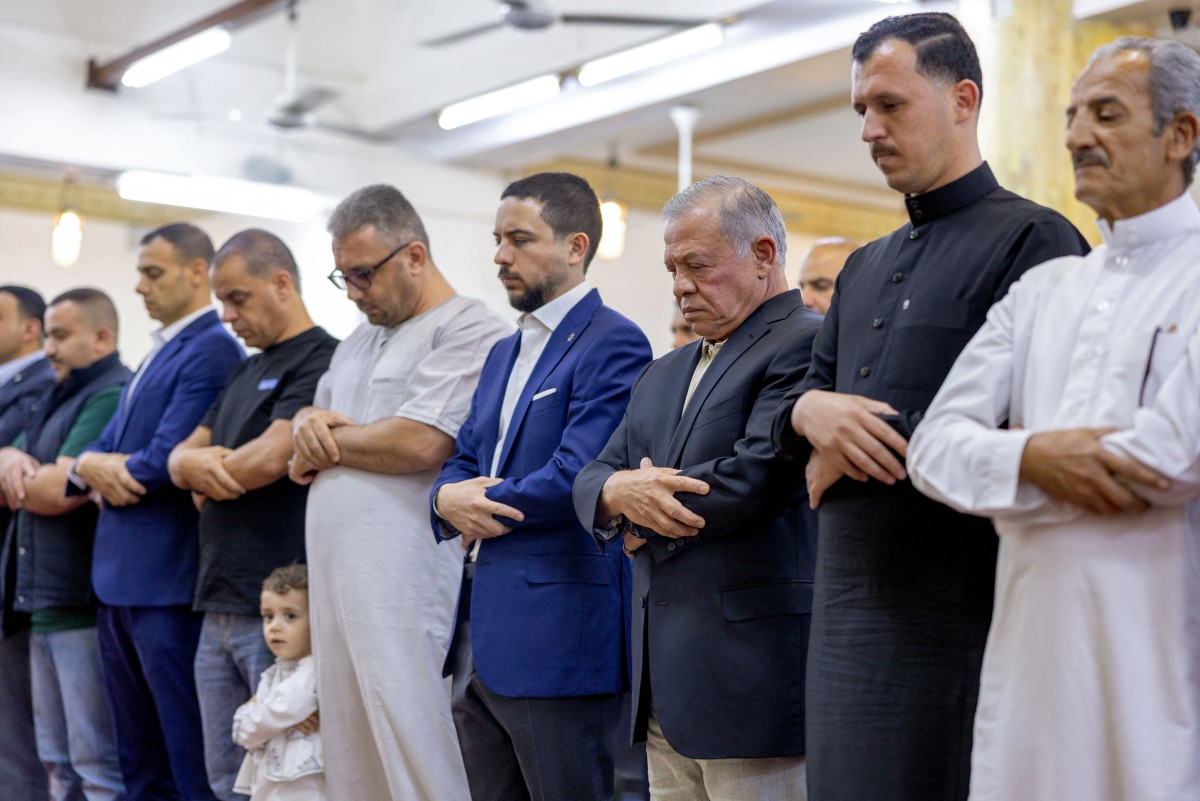 الملك عبد الله الثاني (الثالث من اليمين) ونجله ولي العهد الأمير حسين (في الوسط) إلى جانب مصلين آخرين أثناء أداء صلاة فجر عيد الأضحى، عيد التضحية الإسلامي، في مسجد عمر بن الخطاب في العقبة. (أ ف ب)