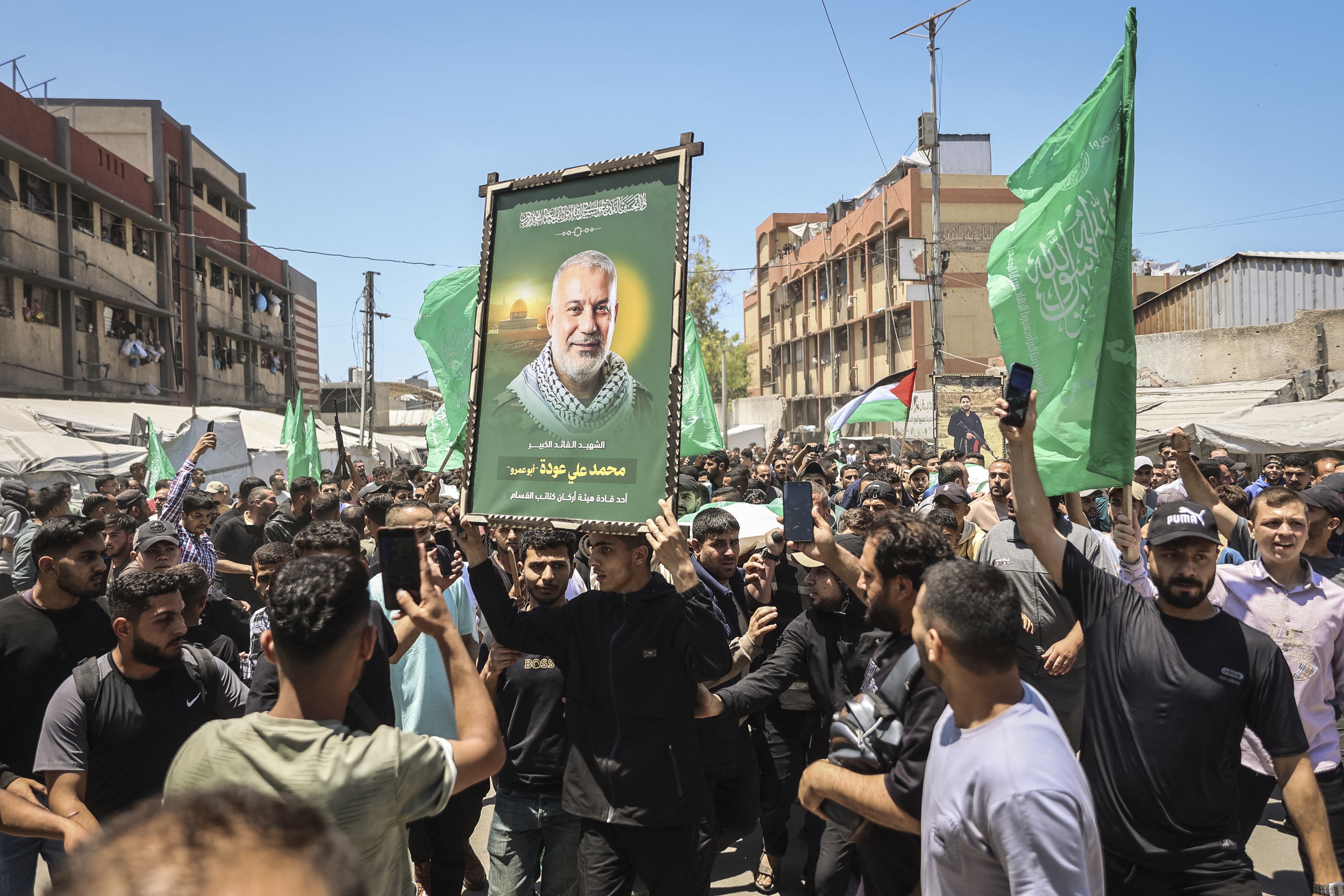 مشيعون يحملون جثمان زعيم الجناح العسكري لحماس محمد عودة وفلسطينيين آخرين بعد اغتياله، خلال جنازته في مدينة غزة، ٢٧ ايار، (أ ف ب).